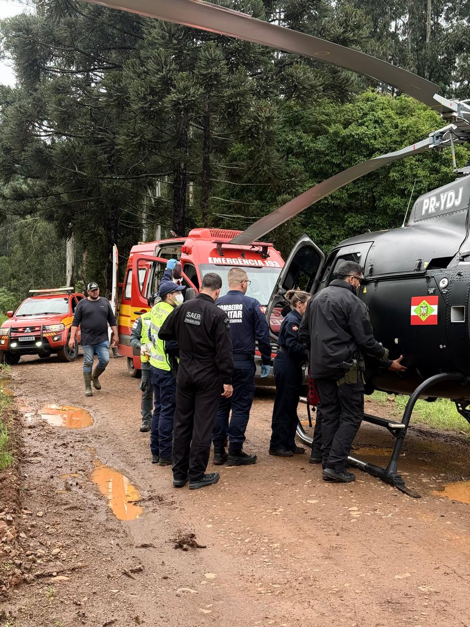 Helicóptero do SAER e viaturas dos Bombeiros em estrada do interior de Faxinal dos Guedes