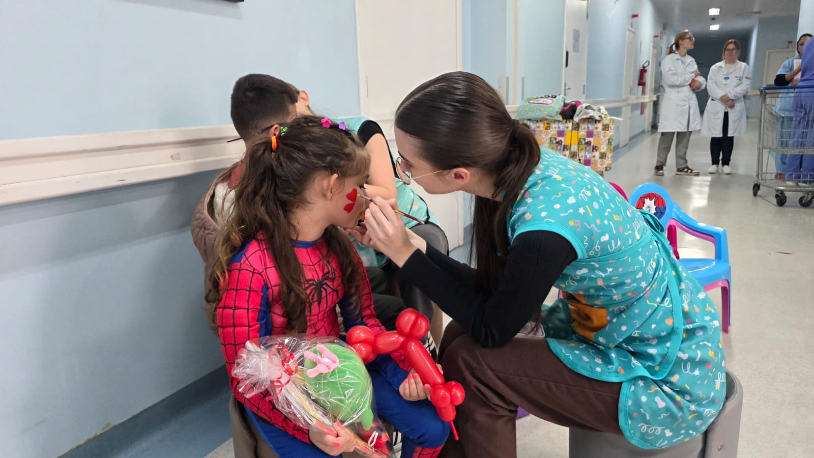 Criança recebe pintura facial durante a festa do Dia das Crianças no hospital