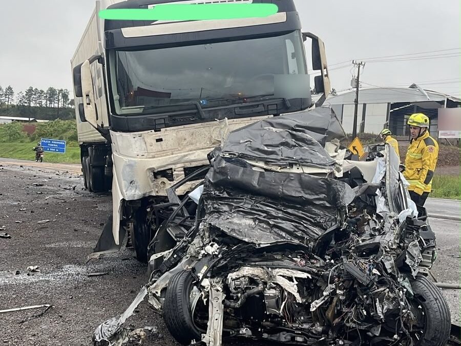 Carro Corolla destruído após colisão frontal com caminhão na BR-282, em Xanxerê, com bombeiro ao lado