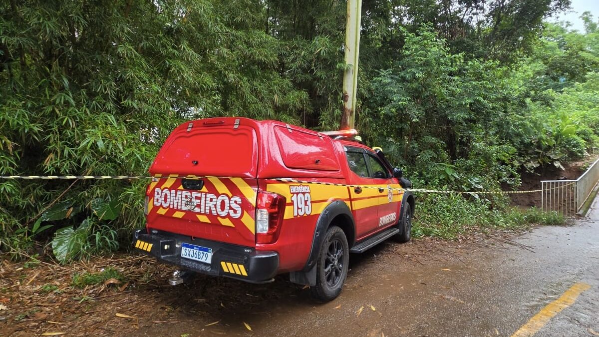 Viatura do Corpo de Bombeiros Militar de Santa Catarina estacionada em estrada de terra, com fita de isolamento, durante buscas por criança em São Carlos