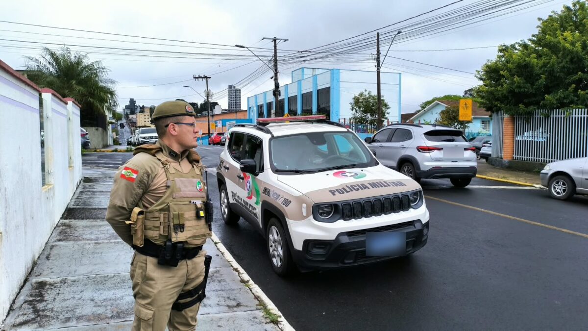 Policial militar da PMSC ao lado de viatura em rua próxima a local de votação